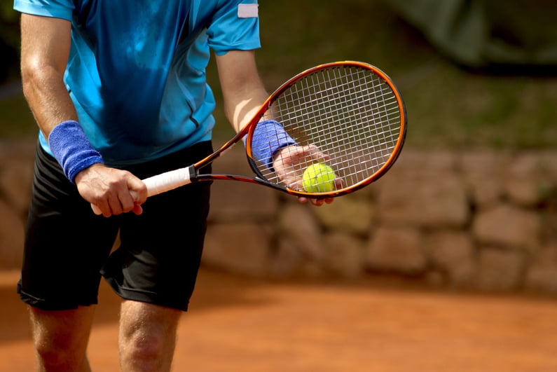 A tennis player prepares to serve a tennis ball during a match