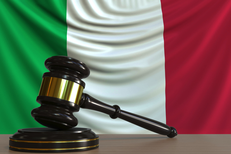 Judge's gavel with Italian flag in background