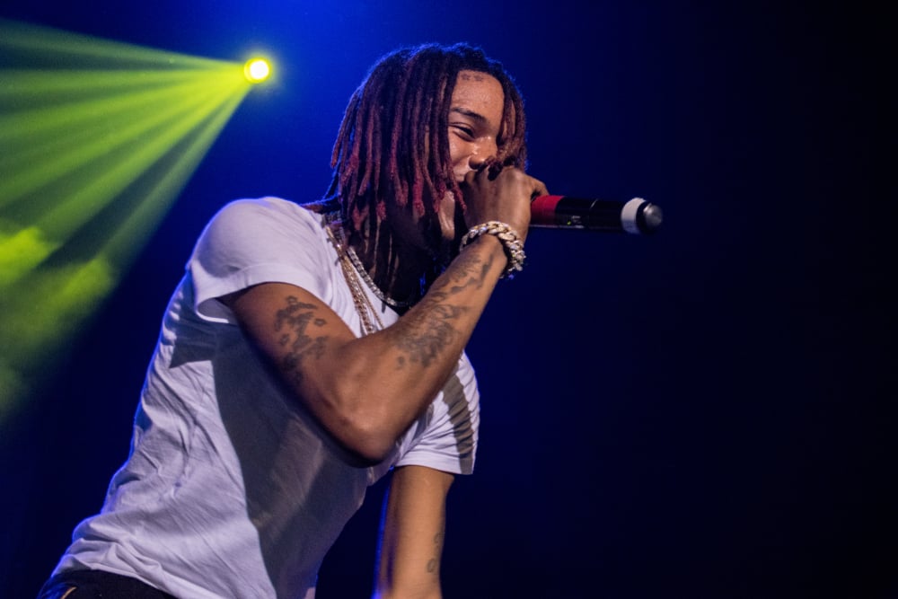 rapper Fetty Wap holding wireless microphone on lit stage