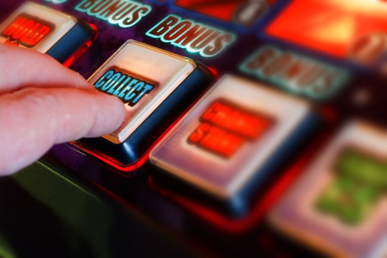 gambler pressing button on a fruit machine