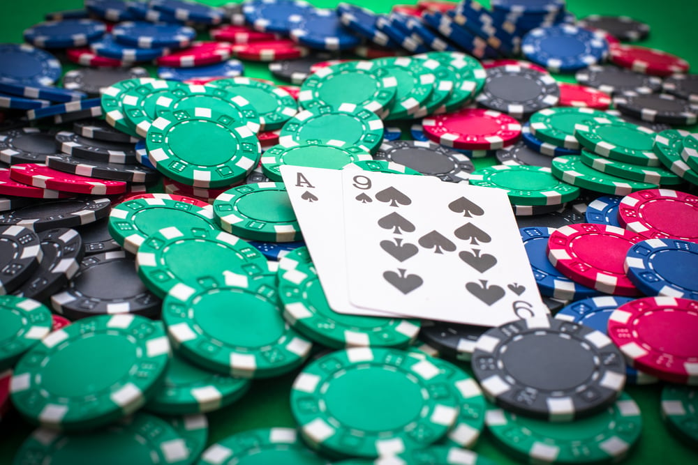 A-9 of spades on top of a pile of poker chips