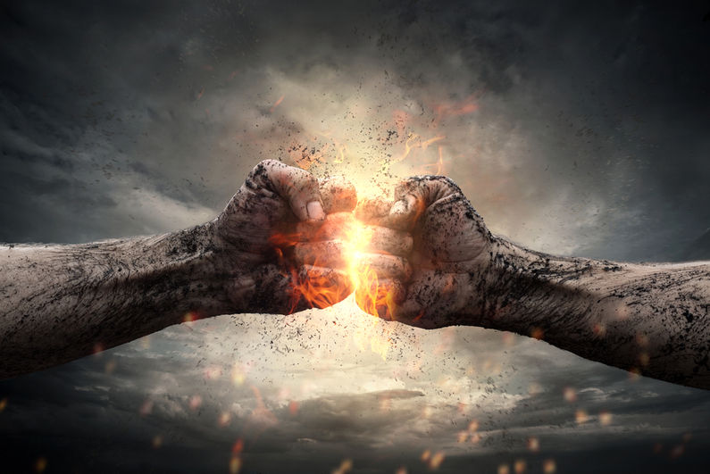 Two fists hitting each other under dramatic sky