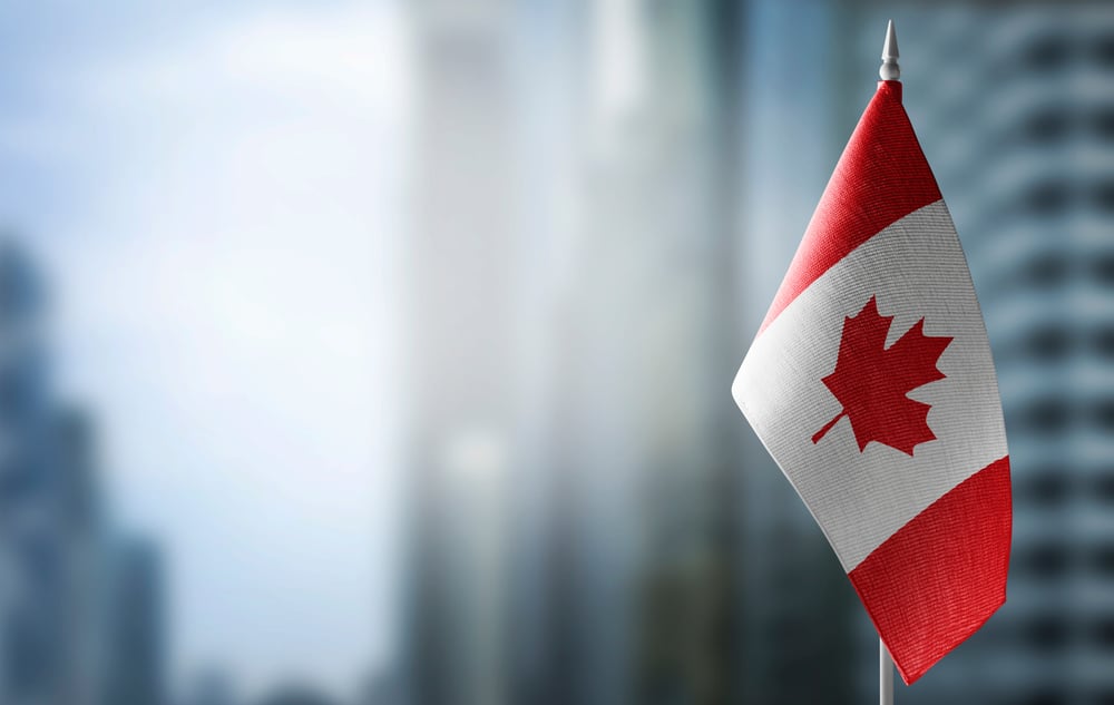 Canada flag against blurred city background